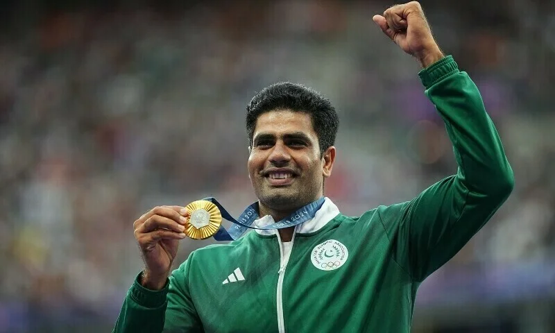 Arshad Nadeem smiles while holding his Olympic gold medal